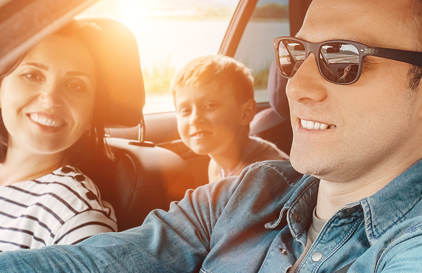 Happy family enjoying a summer road trip in their Kia