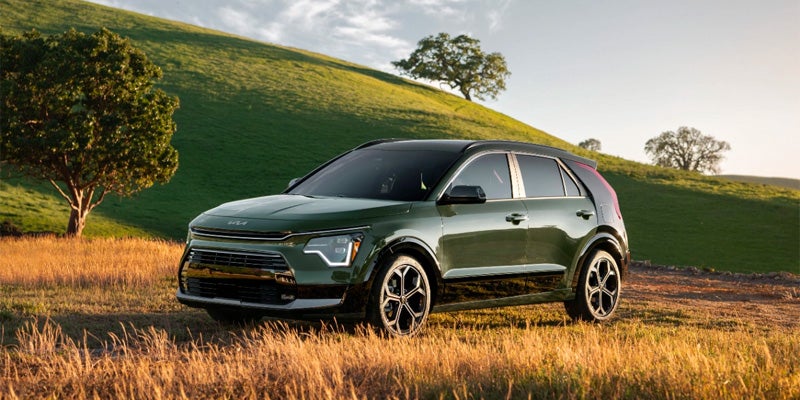 A green Kia Niro sitting in a field